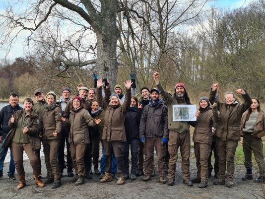 Gruppenfoto mit Berliner Stadtnatur-Ranger*innen, die feierlich die Hände in die Luft strecken 